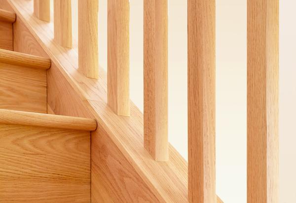 Refinished hardwood stair treads with dark railings in a Kansas City property